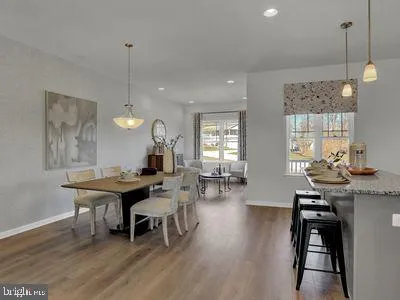 a dining room with wooden floor a chandelier a wooden table and chairs