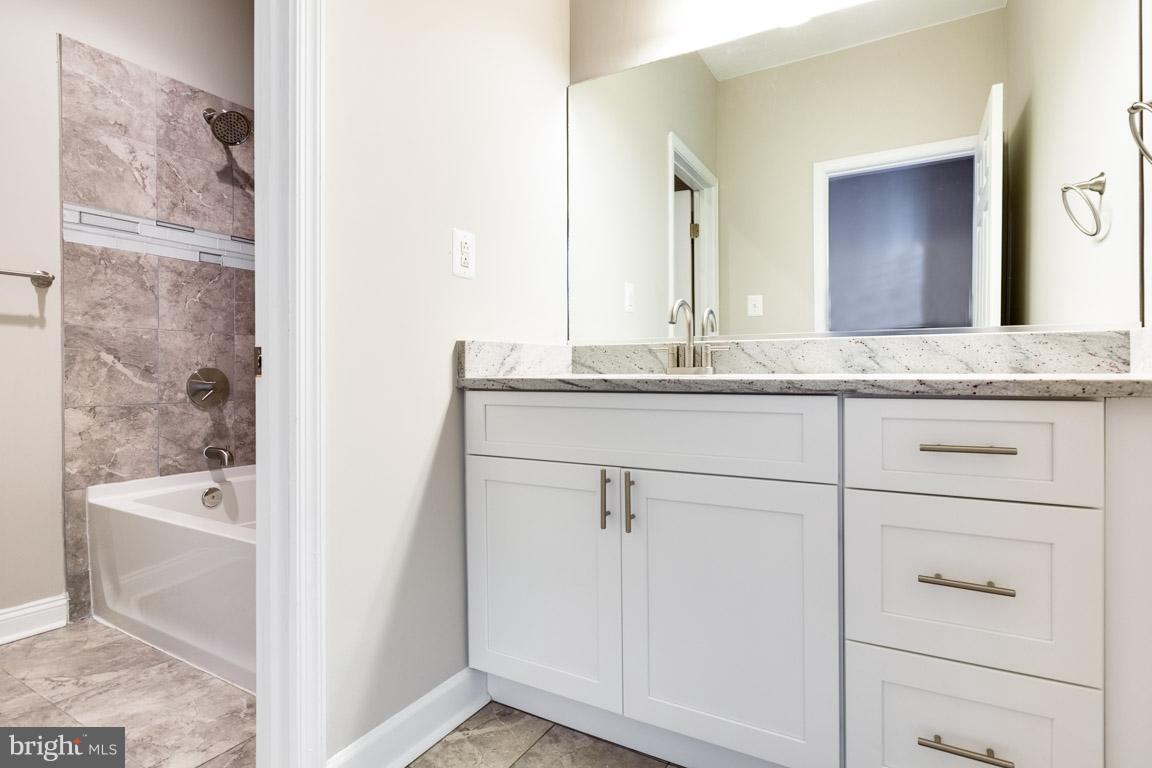 1631 U Street Southeast Washington, DC 20020 - Photo 17 of 24 a bathroom with a granite countertop sink and a mirror