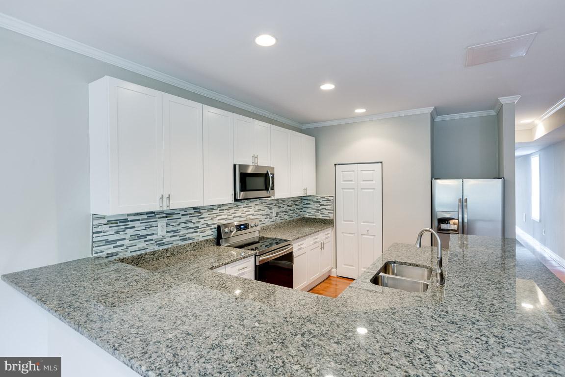 1631 U Street Southeast Washington, DC 20020 - Photo 4 of 24 a kitchen with stainless steel appliances granite countertop a sink stove and refrigerator