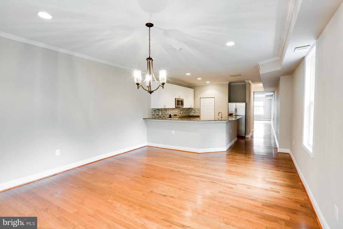 1631 U Street Southeast Washington, DC 20020 - Photo 7 of 24 a view of a kitchen with a refrigerator wooden floor and a chandelier