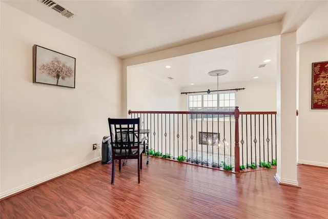 a view of a hallway with wooden floor and a window