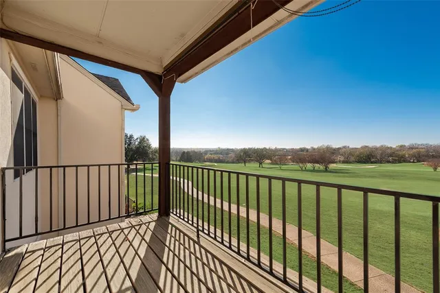a view of a balcony with wooden floor and fence