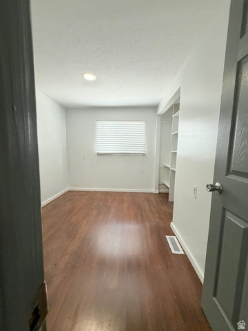 2491 Highway 89, Unit 114 Pleasant View, UT 84404 - Photo 13 of 18 Unfurnished room featuring dark wood-type flooring and a textured ceiling