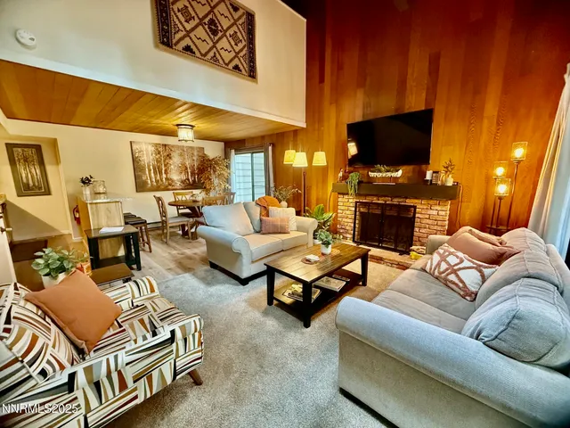 a living room with furniture a flat screen tv and a fireplace