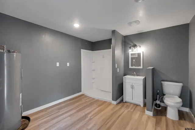 a spacious bathroom with a toilet and a shower