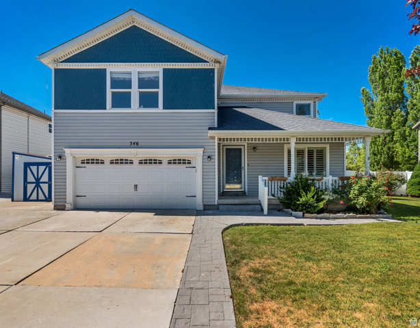 Two-story residence featuring light gray siding with blue shingle accents