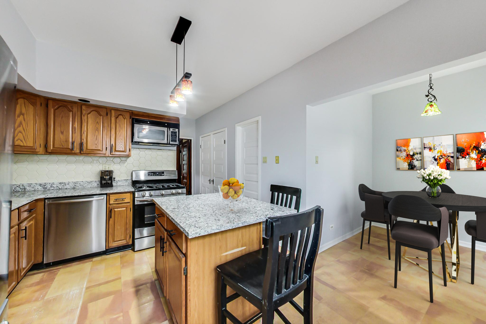 2035 West Rice Street Chicago, IL 60622 - Photo 9 of 27 a kitchen with stainless steel appliances granite countertop table chairs sink and cabinets