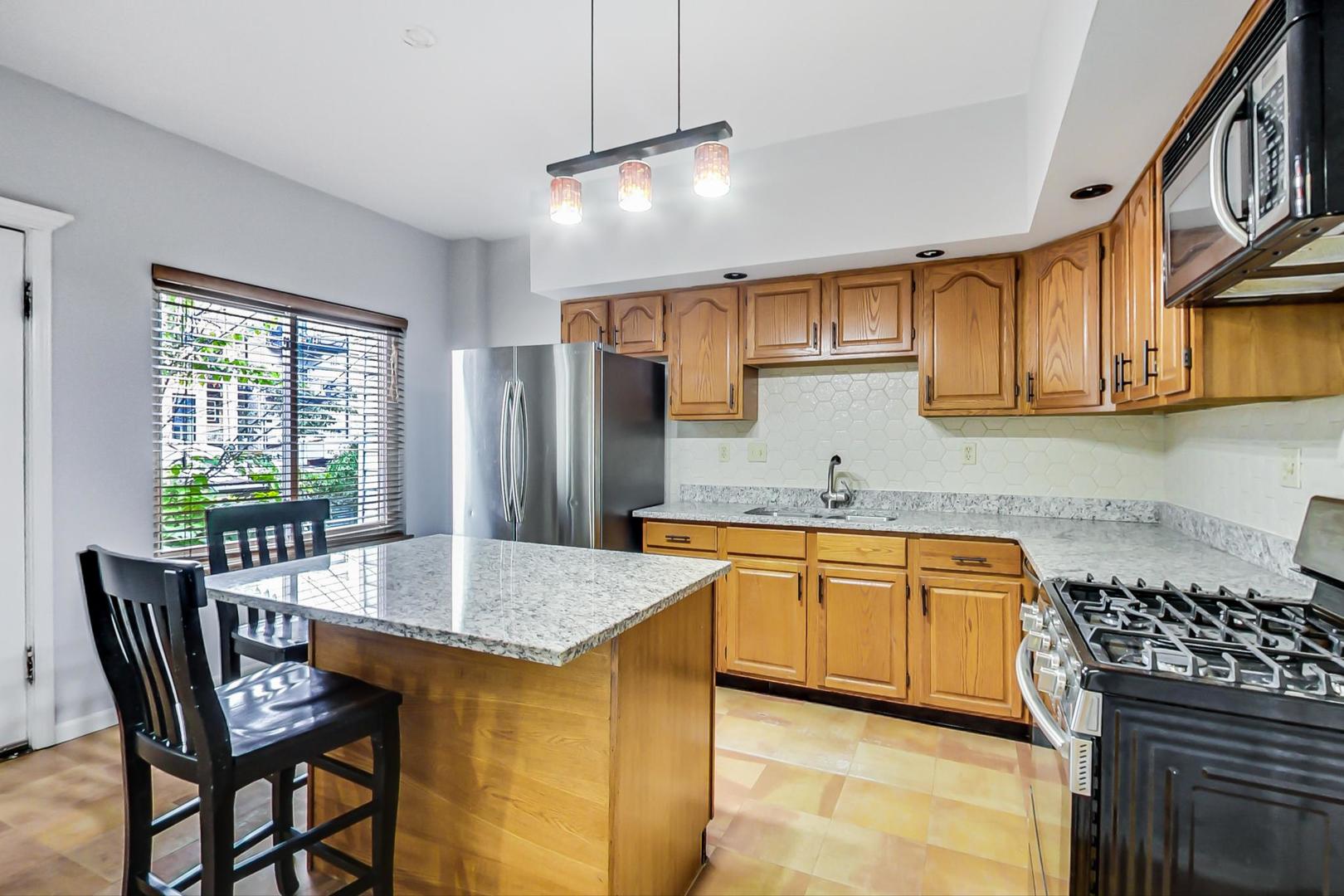 2035 West Rice Street Chicago, IL 60622 - Photo 10 of 27 a kitchen with stainless steel appliances granite countertop a sink stove and refrigerator