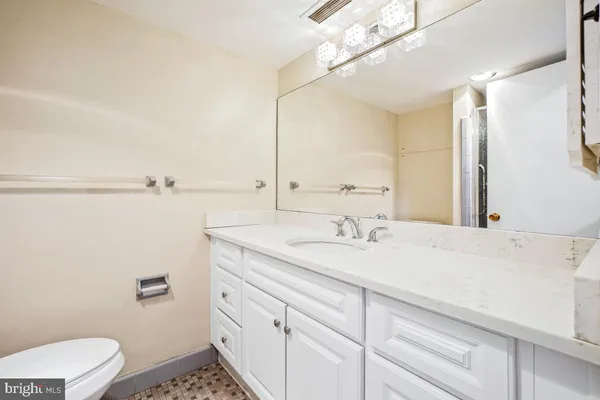 a bathroom with a granite countertop sink a toilet and a mirror