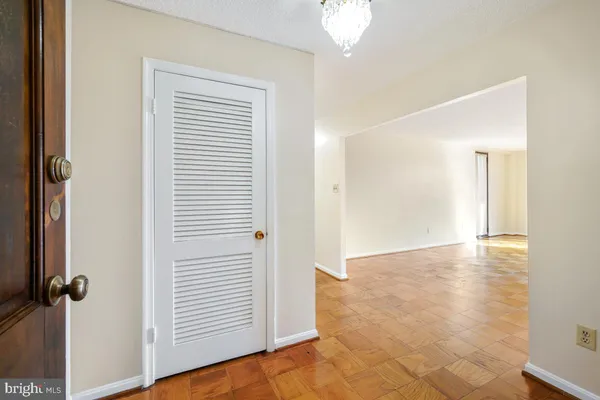 a view of an empty room with closet and a window