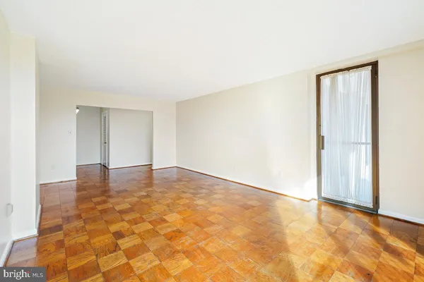 a view of empty room with wooden floor