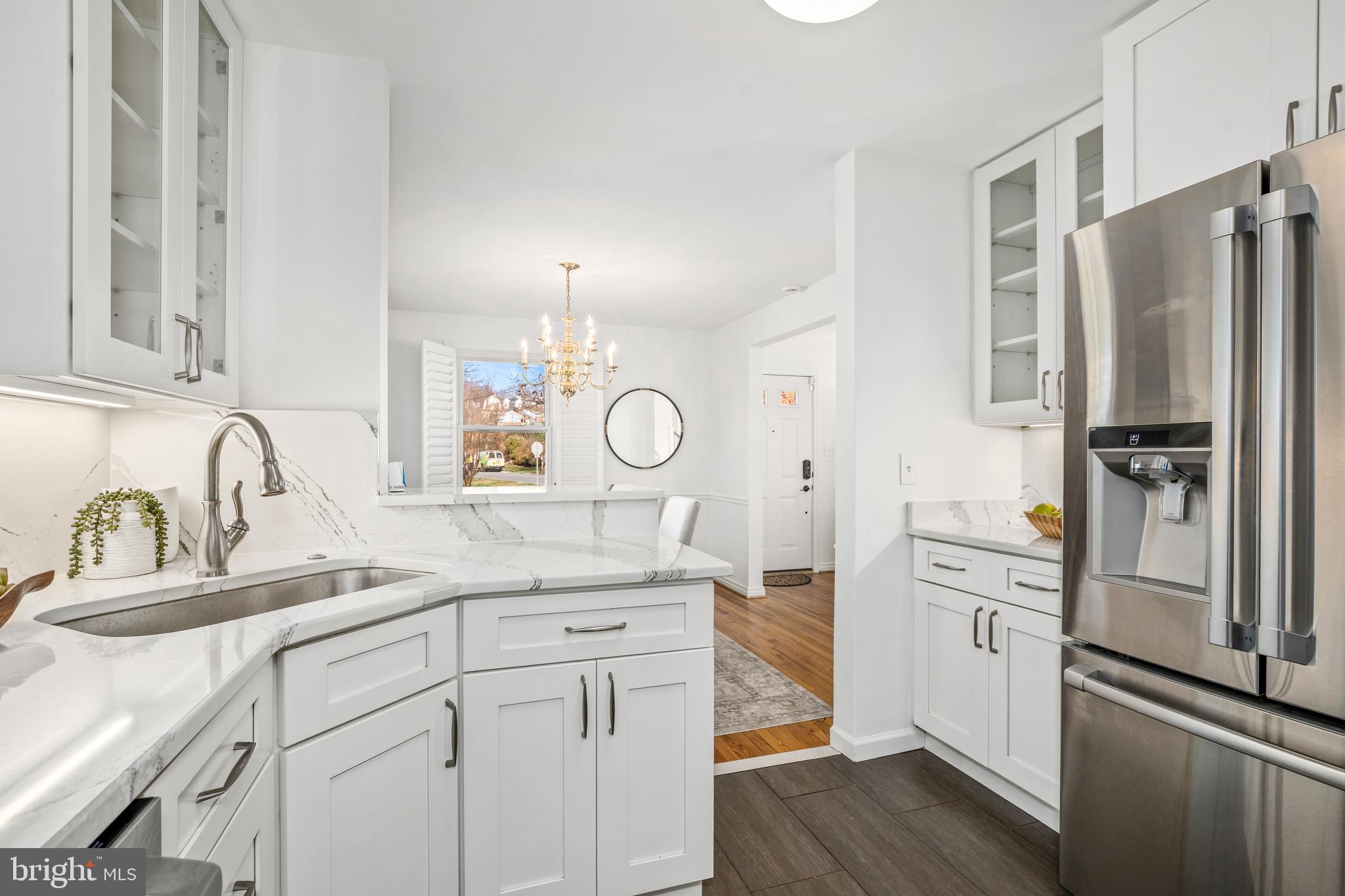 2700 Spencer Road Chevy Chase, MD 20815 - Photo 13 of 40 a kitchen with white cabinets and stainless steel appliances
