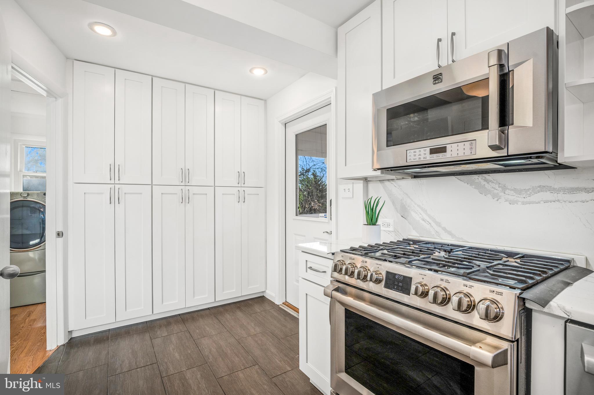 2700 Spencer Road Chevy Chase, MD 20815 - Photo 14 of 40 a kitchen with stainless steel appliances white cabinets and a stove top oven