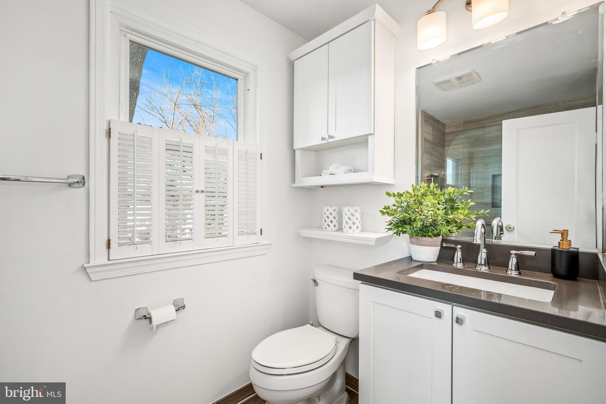 2700 Spencer Road Chevy Chase, MD 20815 - Photo 26 of 40 a bathroom with a granite countertop sink toilet and mirror
