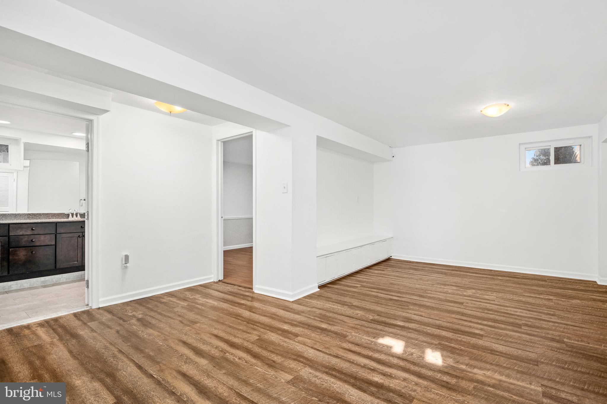 2700 Spencer Road Chevy Chase, MD 20815 - Photo 32 of 40 a view of an empty room with wooden floor and a kitchen