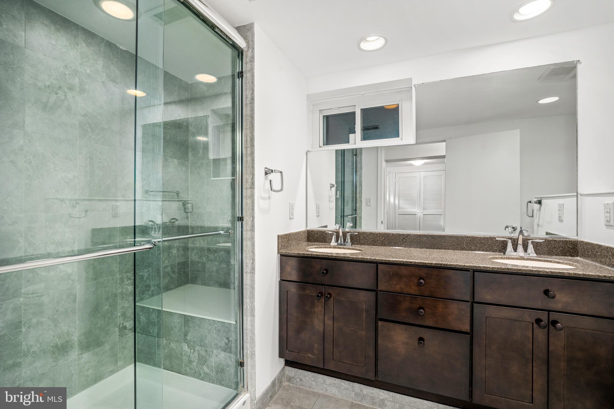 2700 Spencer Road Chevy Chase, MD 20815 - Photo 33 of 40 a bathroom with a double vanity sink mirror and shower