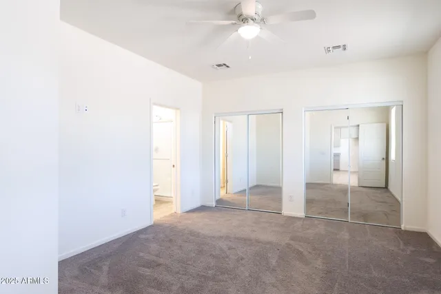 an empty room with a ceiling fan and a window