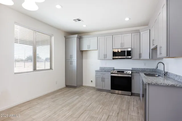 a kitchen with granite countertop cabinets stainless steel appliances and a counter space