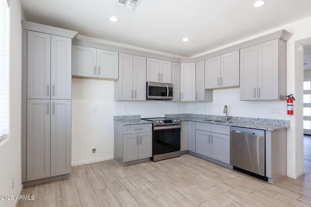 a kitchen with granite countertop white cabinets and a sink