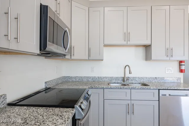 a view of a livingroom with a chandelier fan and windows