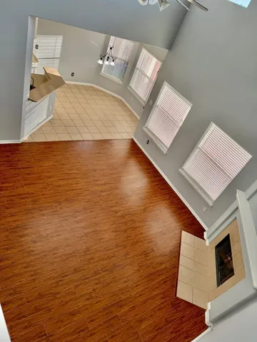 a view of a room with wooden floor and a window