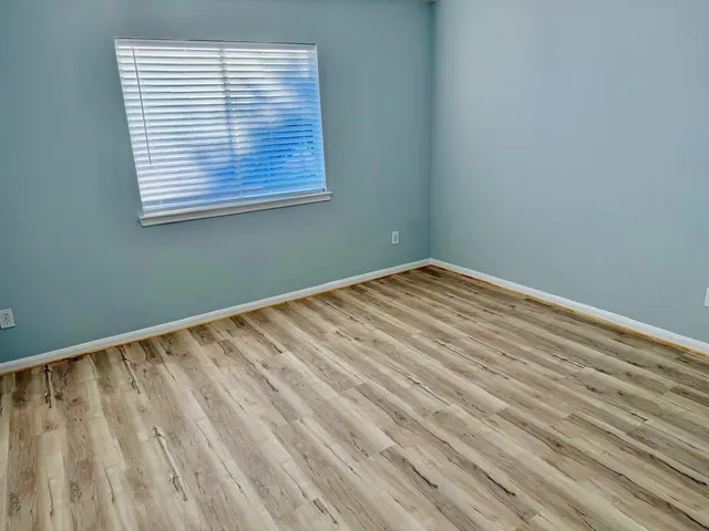 a view of a yard in front of a brick house with large windows