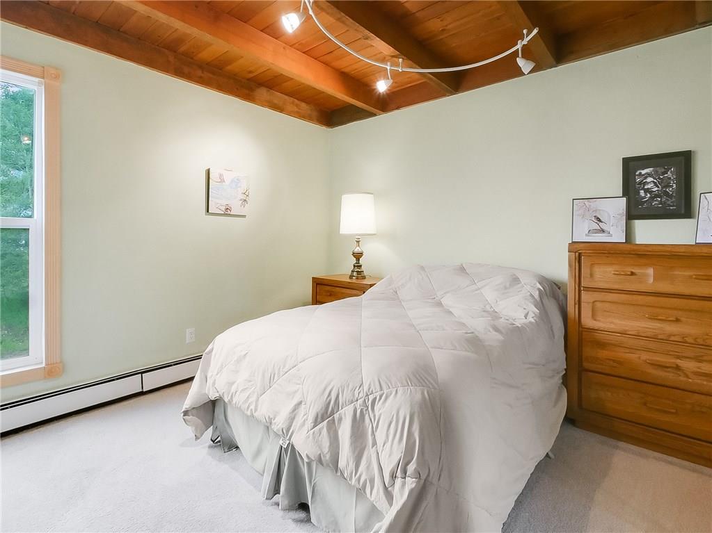 8100 Ryan Gulch Road, Unit E206 Silverthorne, CO 80498 - Photo 11 of 32 a bed with a white comforter and pillows