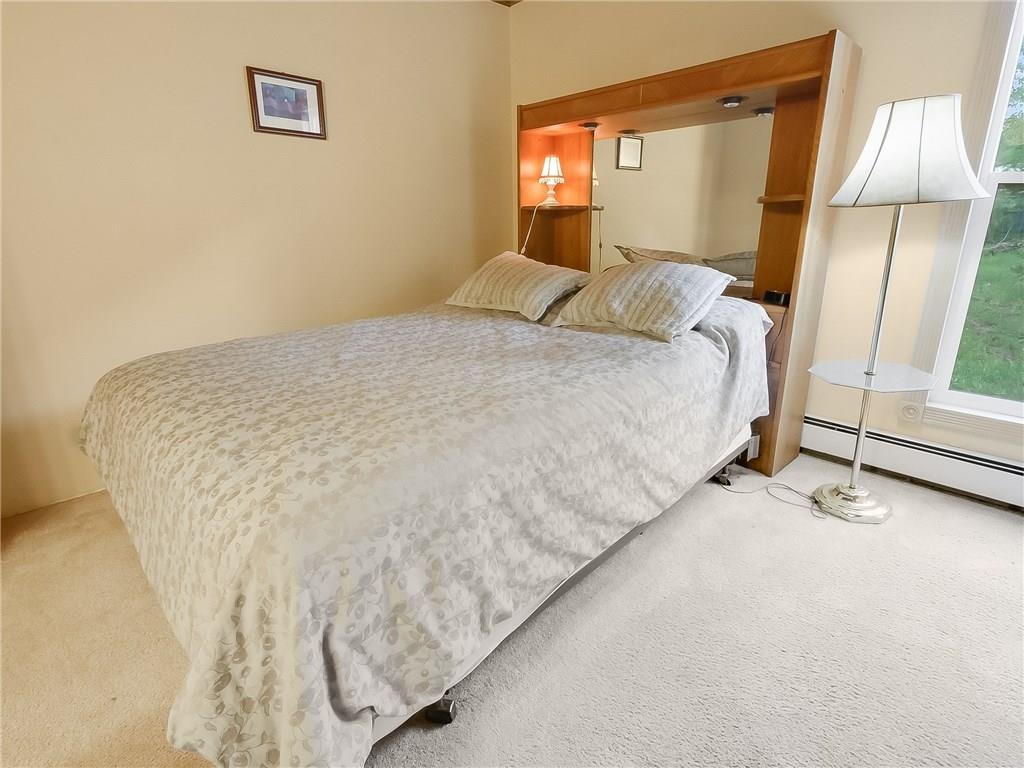 8100 Ryan Gulch Road, Unit E206 Silverthorne, CO 80498 - Photo 12 of 32 a bedroom with a bed and a window