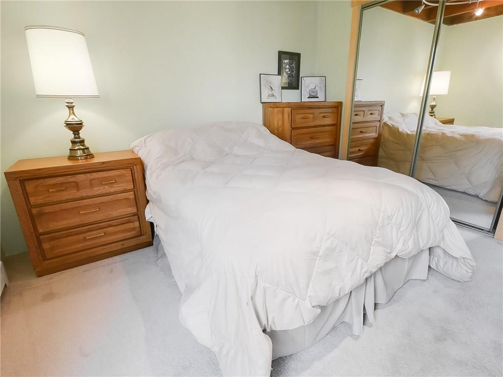 8100 Ryan Gulch Road, Unit E206 Silverthorne, CO 80498 - Photo 16 of 32 a bedroom with a bed and a lamp on table