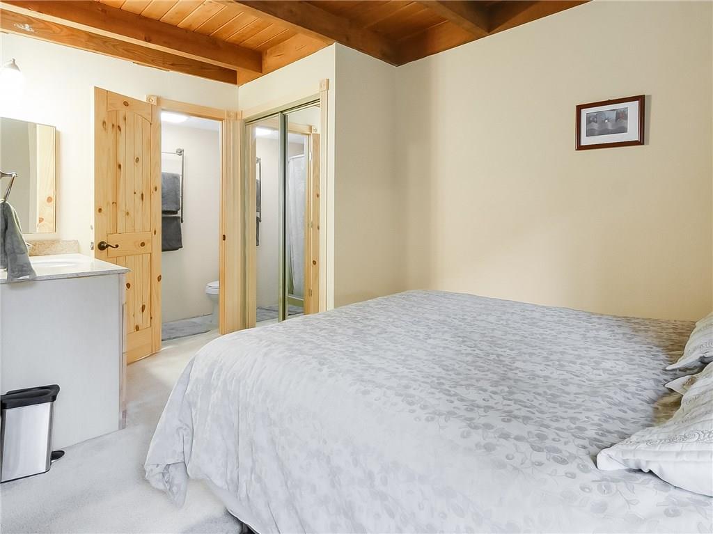 8100 Ryan Gulch Road, Unit E206 Silverthorne, CO 80498 - Photo 18 of 32 a bedroom with a bed and a cabinets