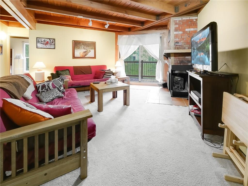 8100 Ryan Gulch Road, Unit E206 Silverthorne, CO 80498 - Photo 22 of 32 a living room with furniture a flat screen tv and a fireplace
