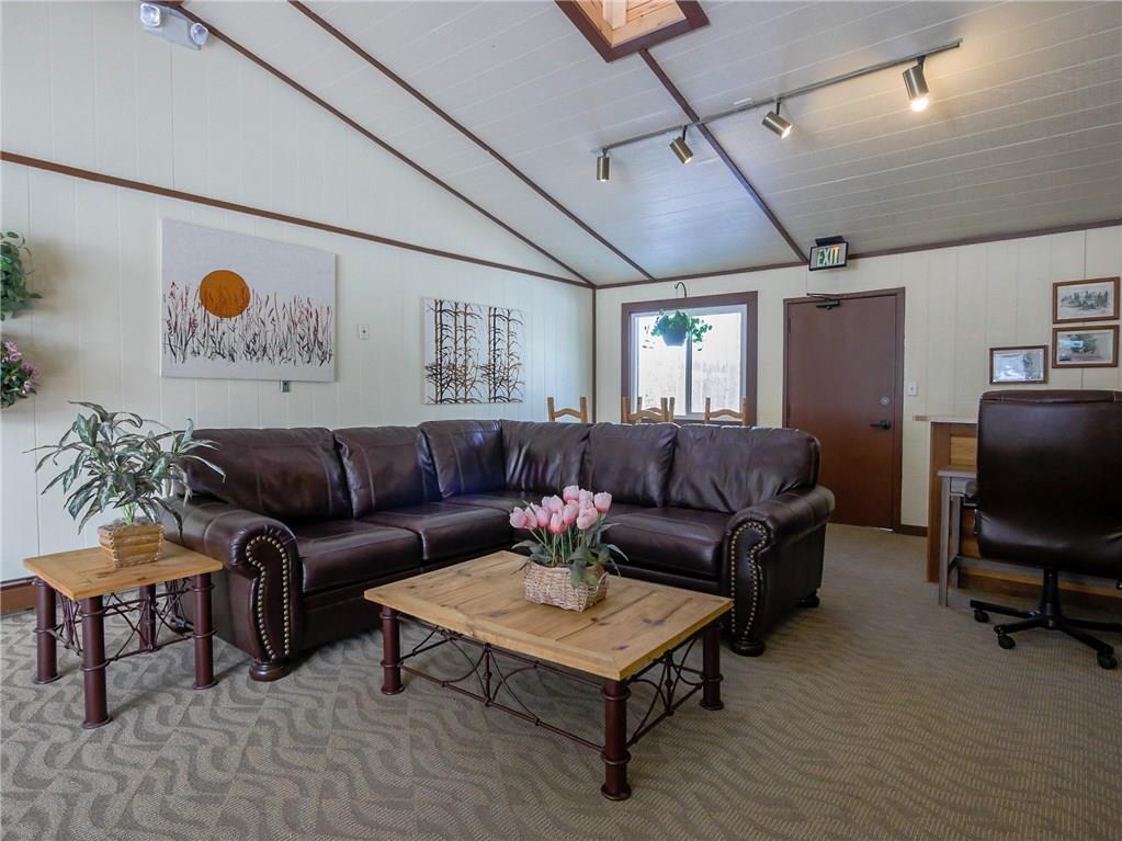 8100 Ryan Gulch Road, Unit E206 Silverthorne, CO 80498 - Photo 30 of 32 a living room with furniture and a flat screen tv