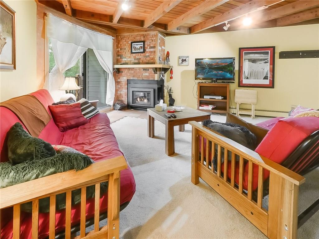 8100 Ryan Gulch Road, Unit E206 Silverthorne, CO 80498 - Photo 5 of 32 a living room with furniture fireplace and flat screen tv