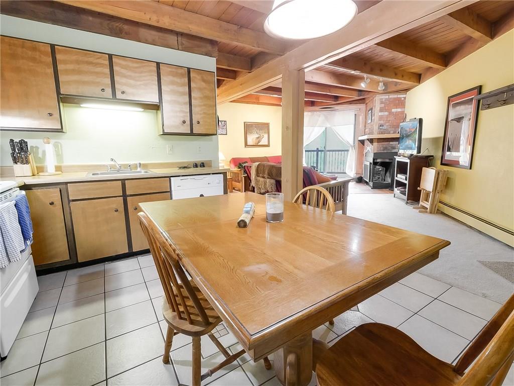 8100 Ryan Gulch Road, Unit E206 Silverthorne, CO 80498 - Photo 7 of 32 a dining table with chairs and window