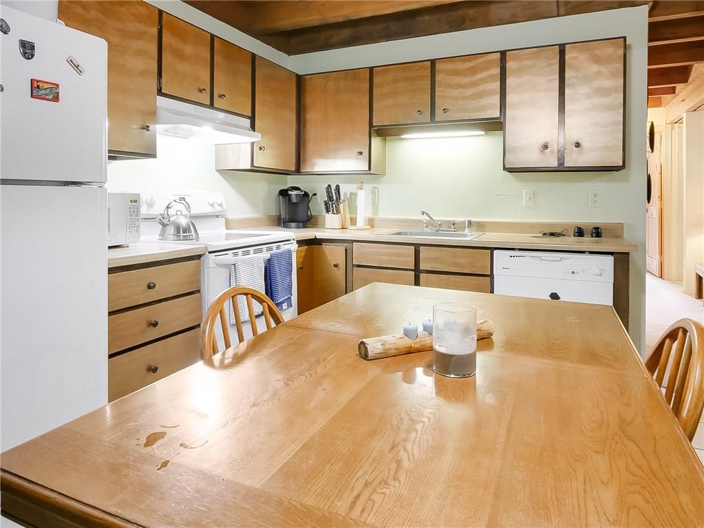 8100 Ryan Gulch Road, Unit E206 Silverthorne, CO 80498 - Photo 9 of 32 a kitchen with granite countertop a sink a stove and cabinets