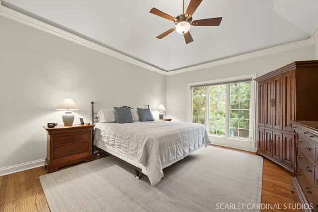 a bedroom with a large bed chandelier and a window