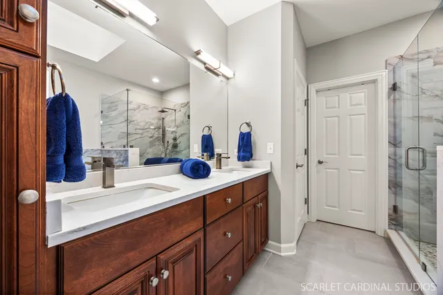a bathroom with a double vanity sink mirror and shower