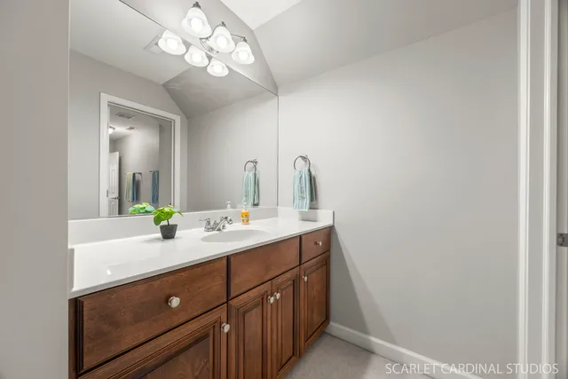 a bathroom with a sink a light fixture and a mirror
