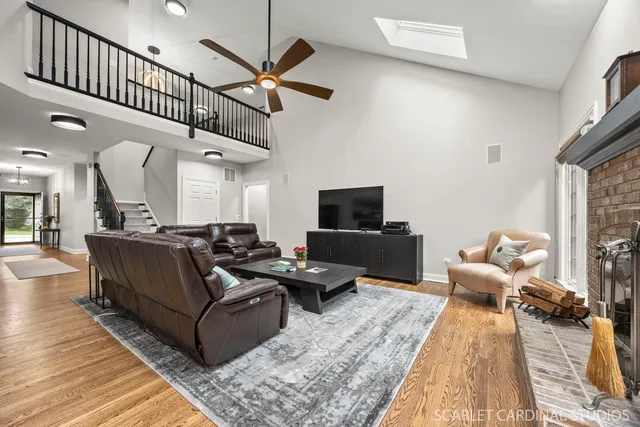 a living room with furniture wooden floor and a ceiling fan