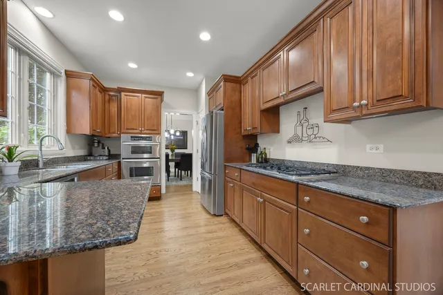 a kitchen with stainless steel appliances granite countertop wooden cabinets a stove a sink and a granite counter top