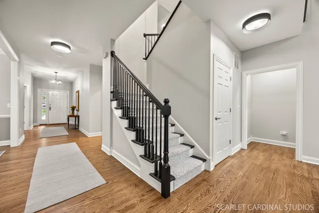 a view of a hallway with wooden floor and staircase