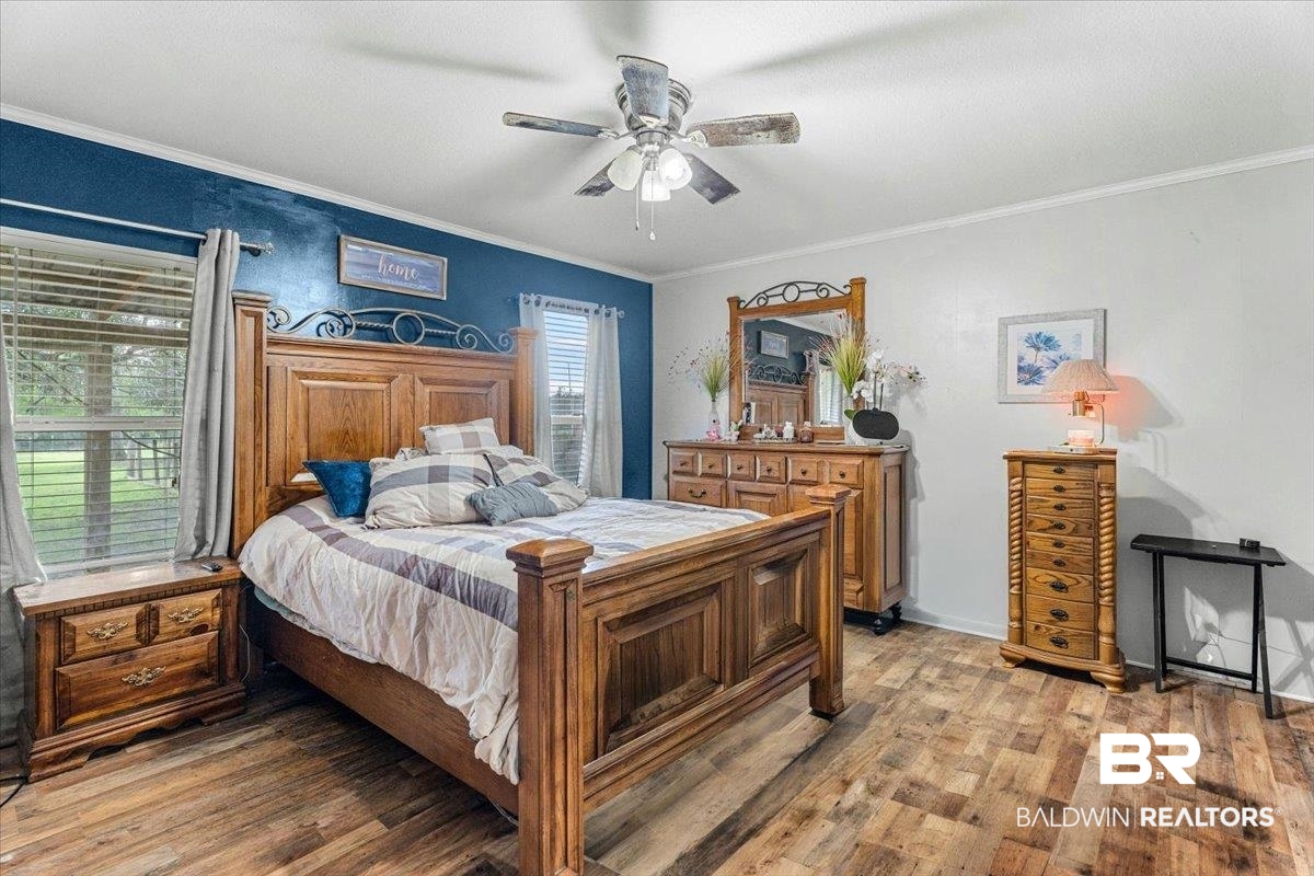 21011 River Road Robertsdale, AL 36567 - Photo 12 of 29 Spacious room featuring wood-finish flooring, a ceiling fan, and multiple windows with blinds