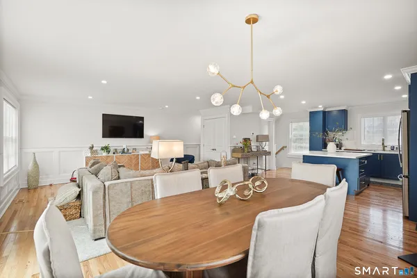 a living room with furniture a flat screen tv and a wooden floor