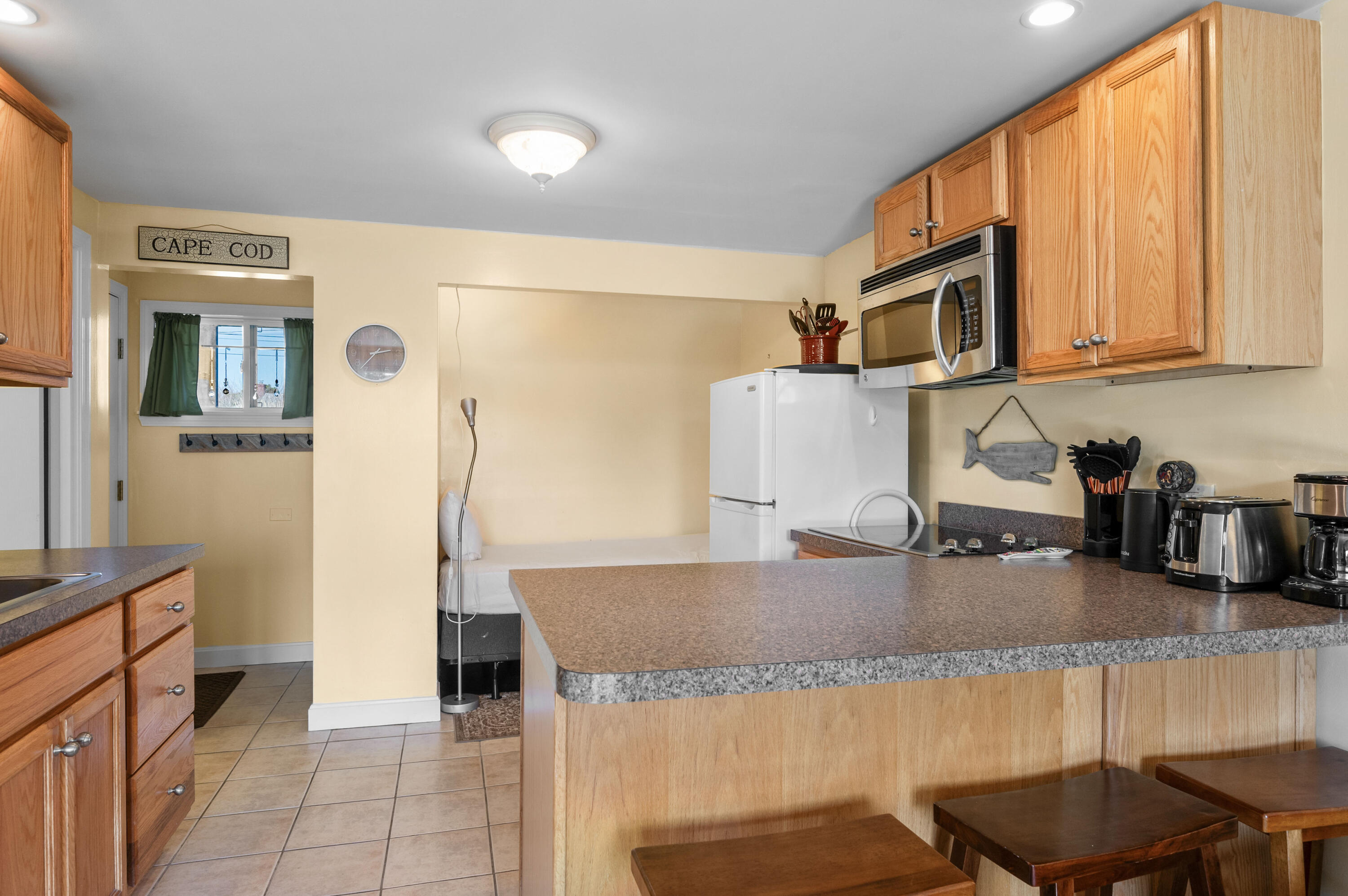 132 Shore Road, Unit 9 Truro, MA 02666 - Photo 7 of 28 a kitchen with stainless steel appliances granite countertop a sink and a refrigerator