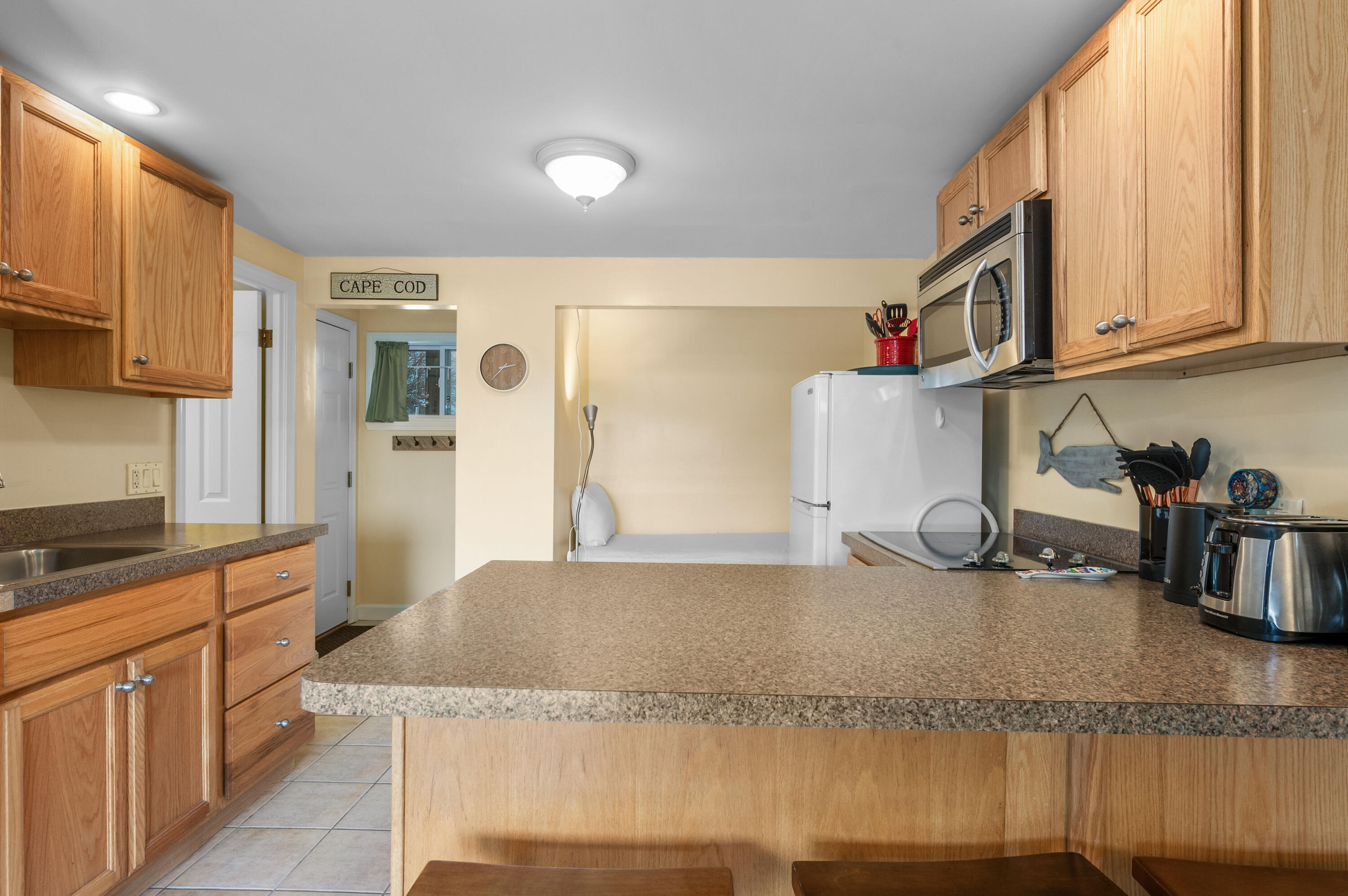132 Shore Road, Unit 9 Truro, MA 02666 - Photo 8 of 28 a kitchen with granite countertop a sink and a stove top oven