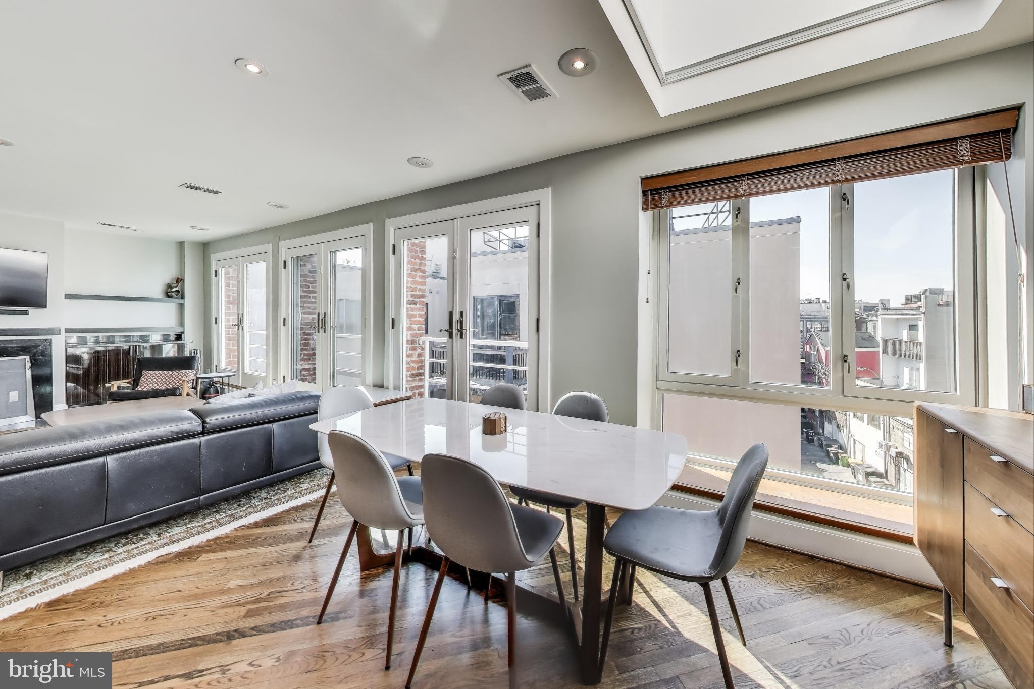 2370 Champlain Street Northwest, Unit 34 Washington, DC 20009 - Photo 3 of 33 a view of a dining room with furniture large windows and wooden floor