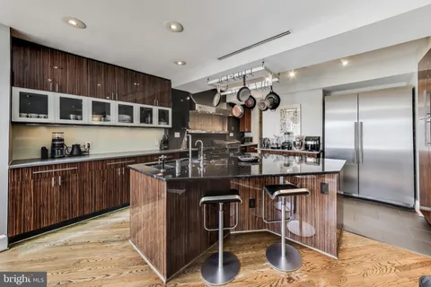 a kitchen with stainless steel appliances granite countertop a sink and a refrigerator