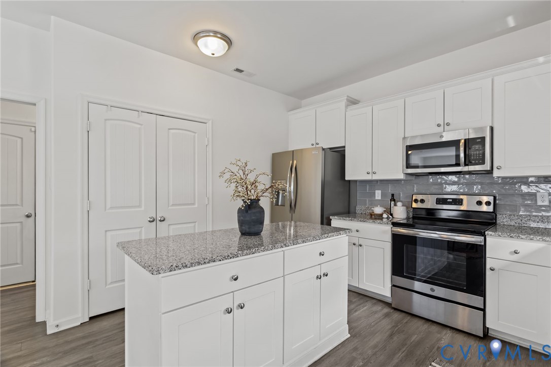 4237 Wells Ridge Court Chester, VA 23831 - Photo 12 of 47 a kitchen with stainless steel appliances granite countertop a stove a sink and a refrigerator