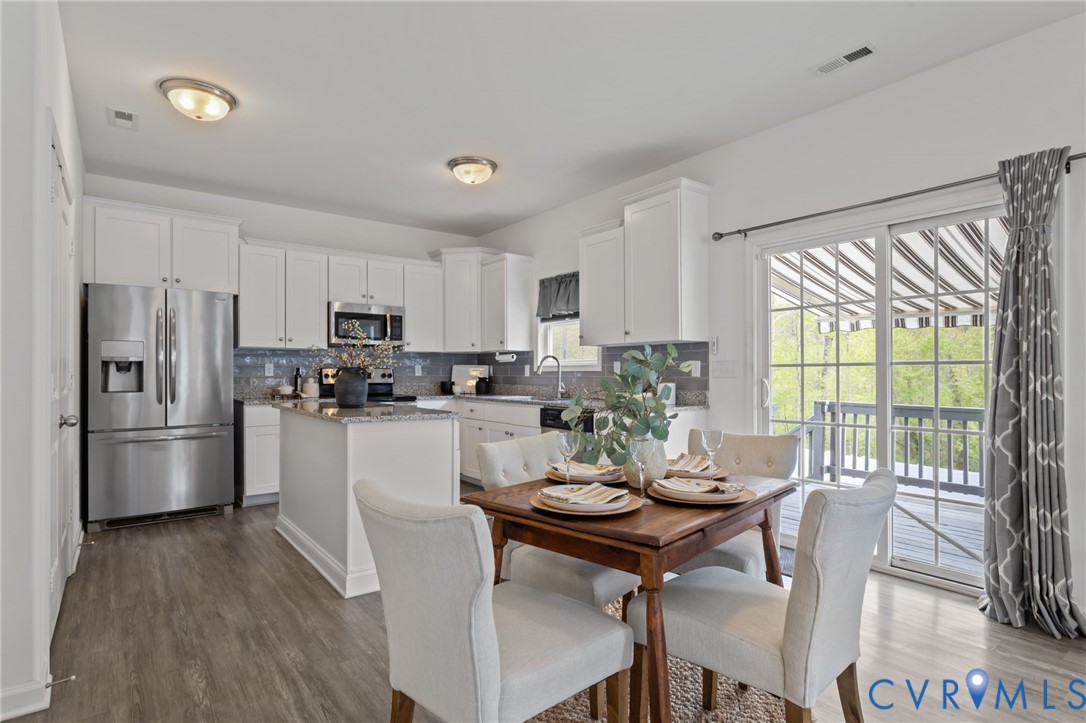 4237 Wells Ridge Court Chester, VA 23831 - Photo 10 of 47 a kitchen with a refrigerator a stove a dining table and chairs