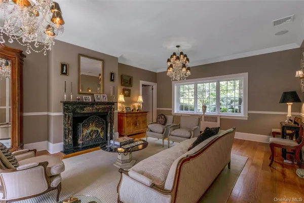 a living room with furniture a fireplace and a chandelier